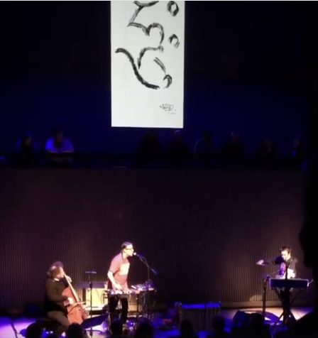 Mike Patton on the mic while Laurie Anderson plays violin at SF Jazz under the drawing of Lou Reed and his exploding heart